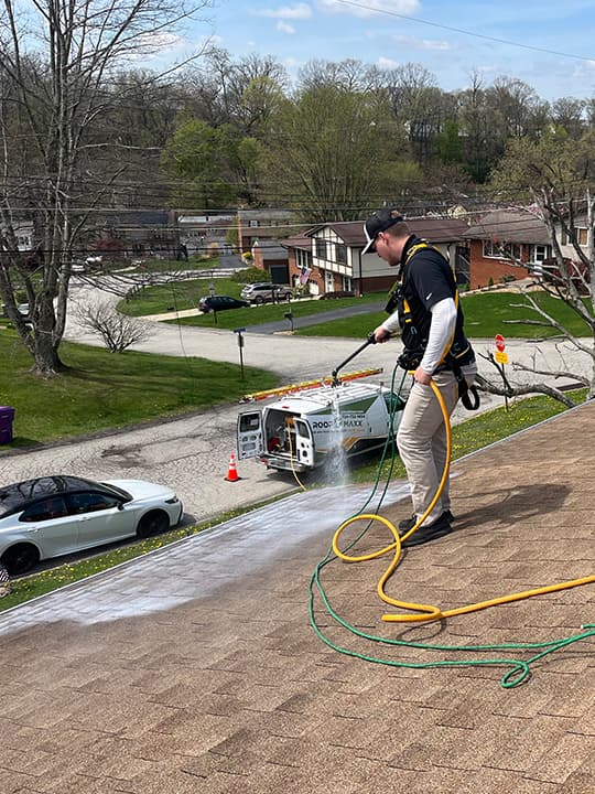 Roof Maxx technician applying roof maxx on a roof