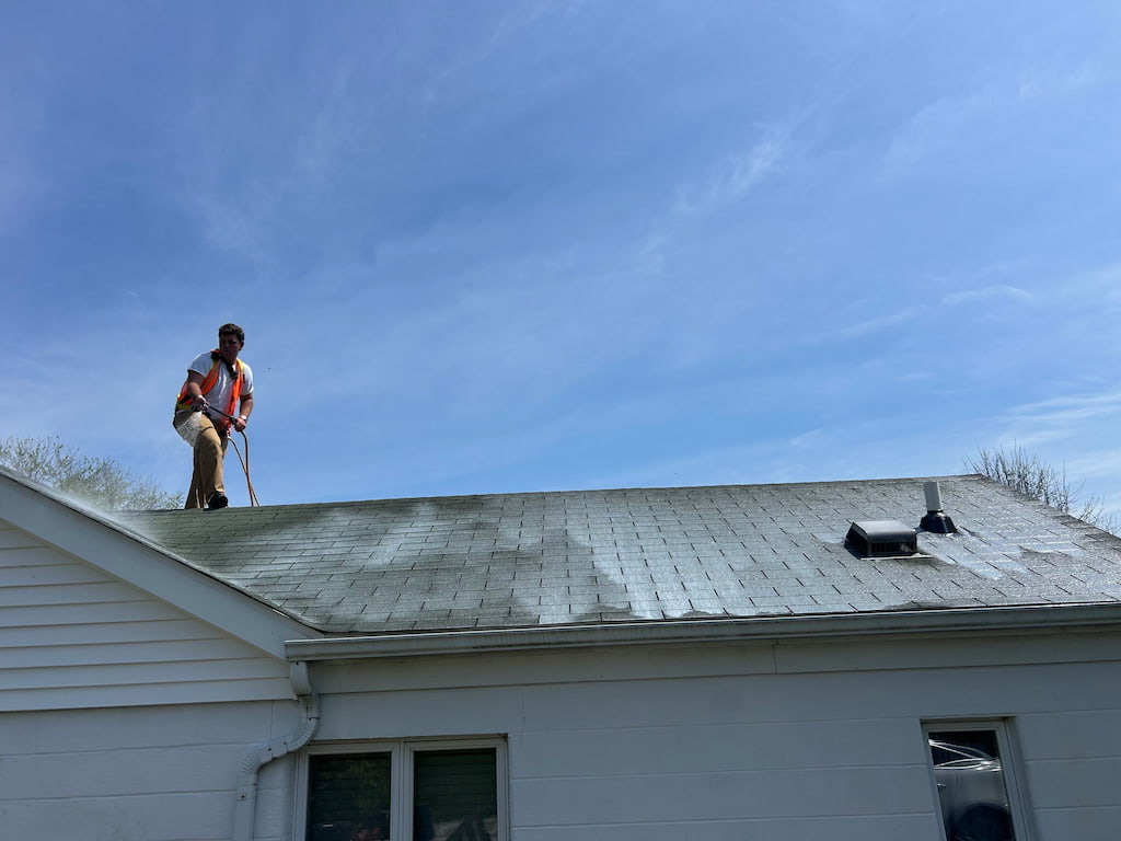 Roof Maxx dealer of Portsmouth, Ohio, on a roof applying the roof maxx product