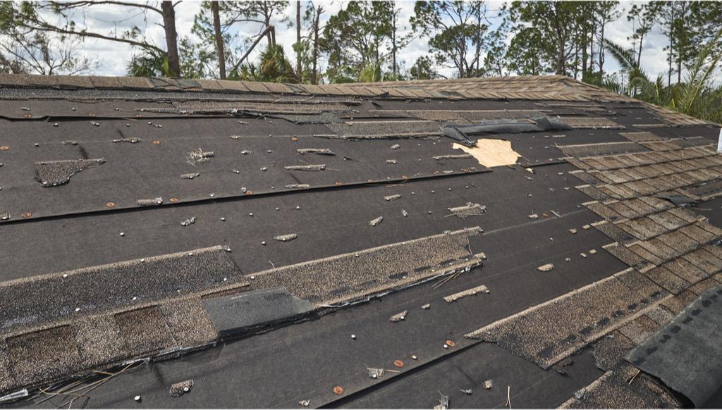 An asphalt shingle roof in the middle of a tear-off job
