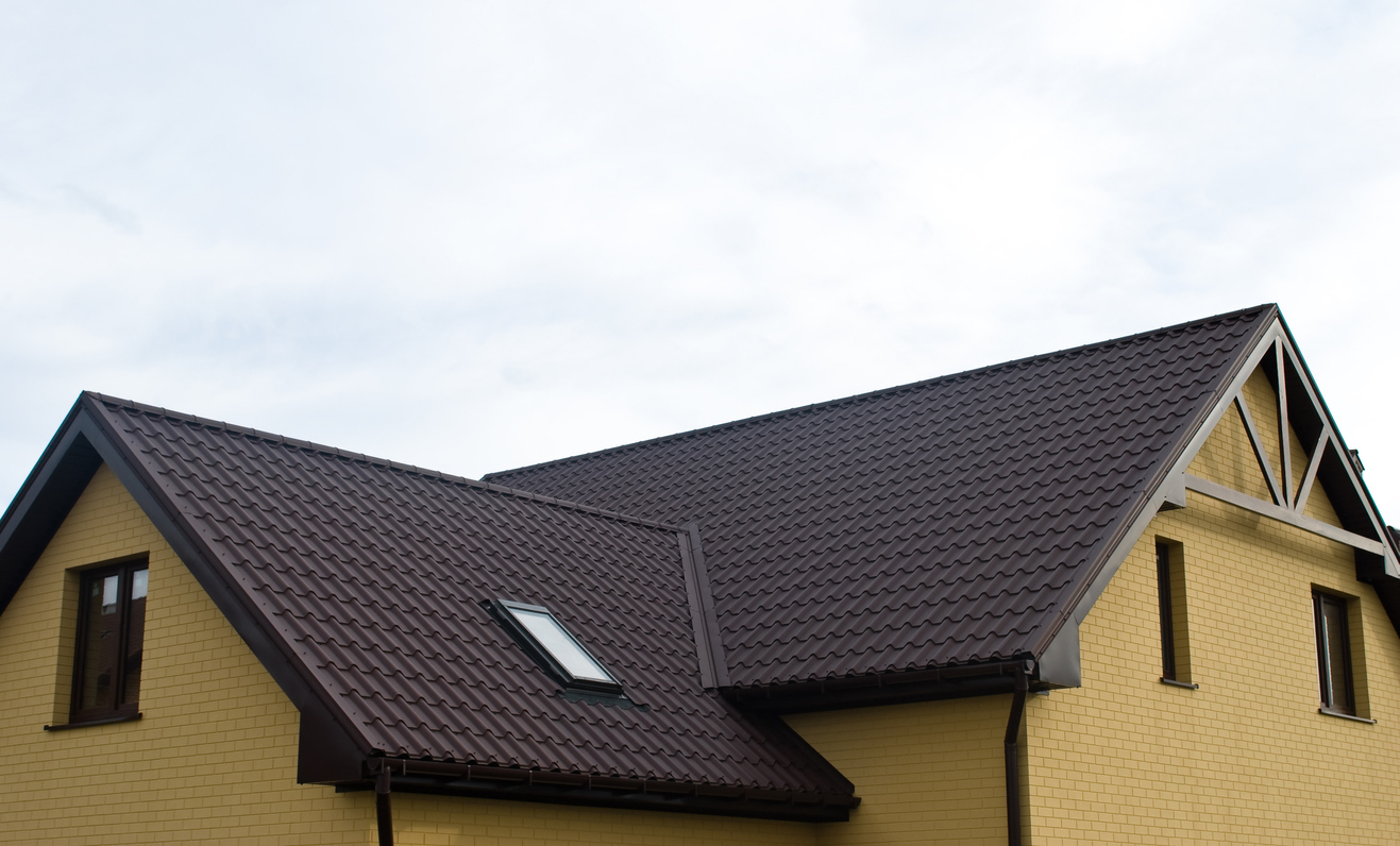 Side view of composite shingles on a yellow brick house