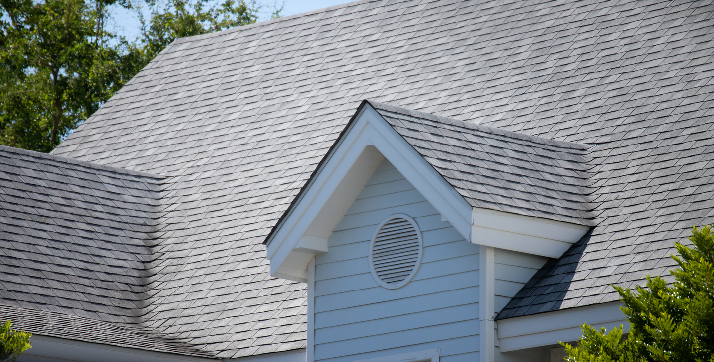 Side view of asphalt shingles on a light blue house