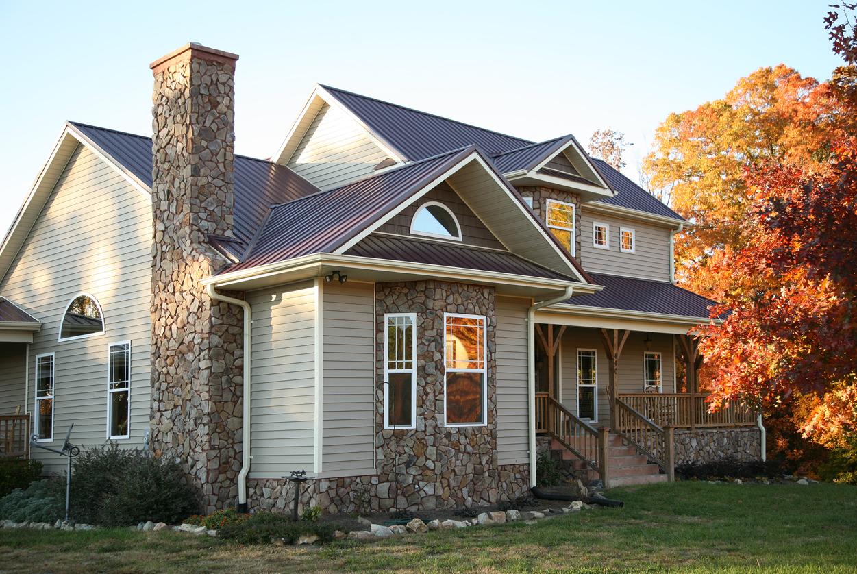 Side view of a residential home with stonework accents and a composite roof
