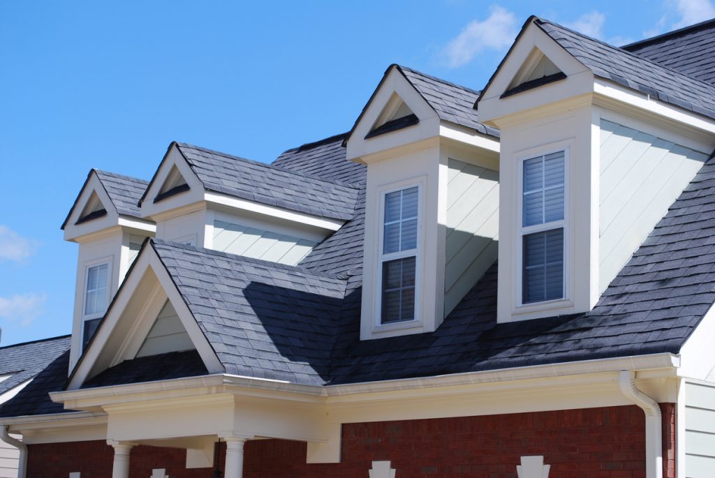 Top of house with a nicely laid out roof of asphalt shingles.