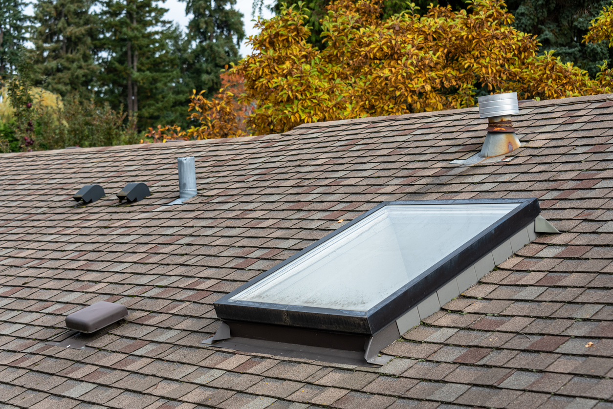a asphalt shingled roof with a skylight on top of it.
