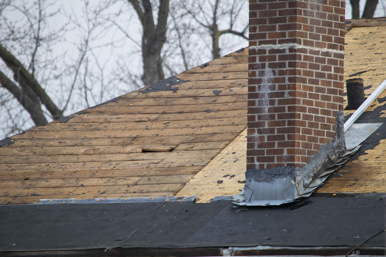 damaged chimney and flashing on top of damaged roof.