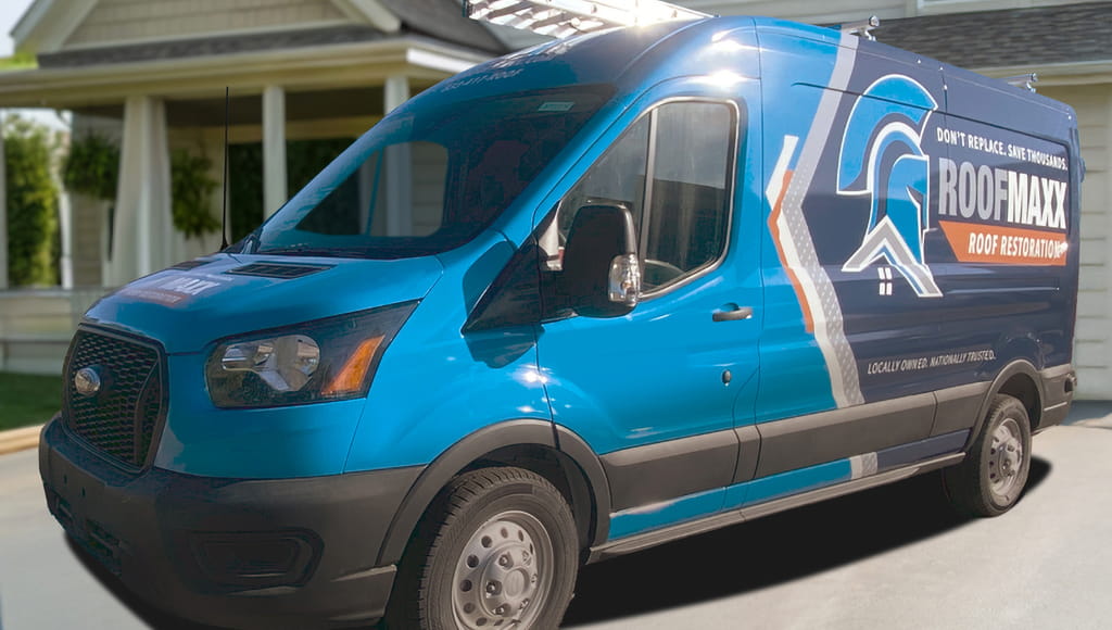 Side shot of a blue Roof Maxx van with branded vinyl wrap