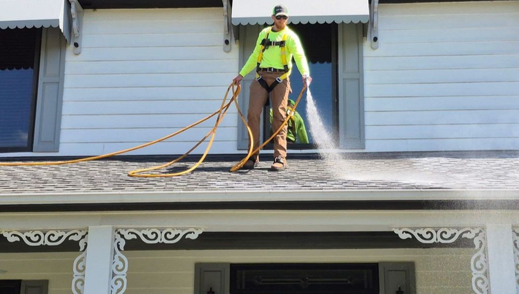 A Roof Maxx dealer sprays the treatment onto the roof of a residential home