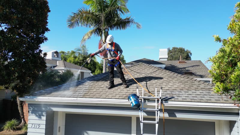 A Roof Maxx dealer sprays the treatment on a customer's roof.