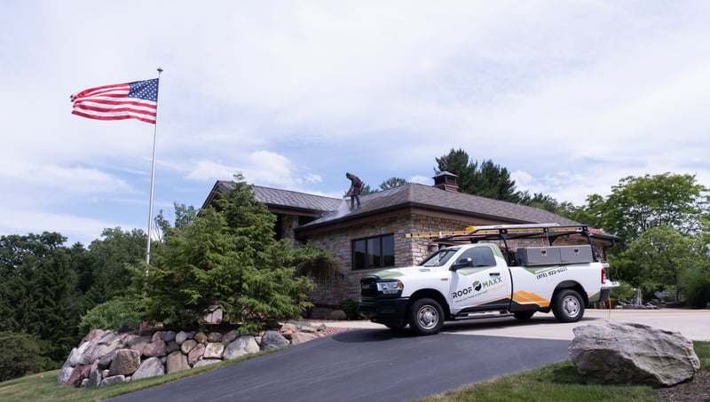 A Roof Maxx truck parked in front of a customer's home