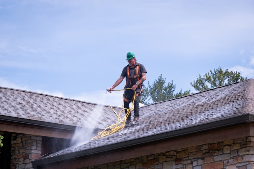 Professional spraying Roof Maxx treatment on roof