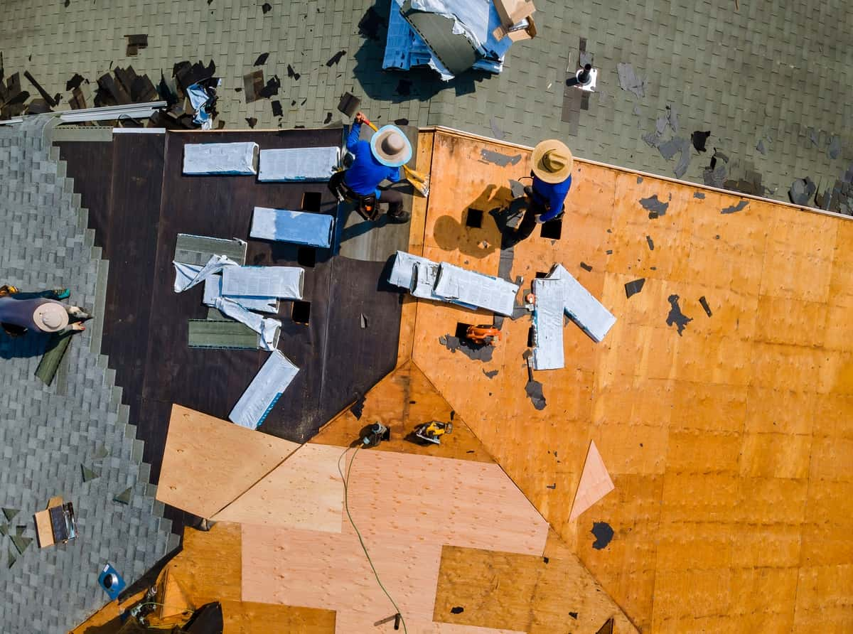 Asphalt shingles being put on roof during extensive roof replacement process