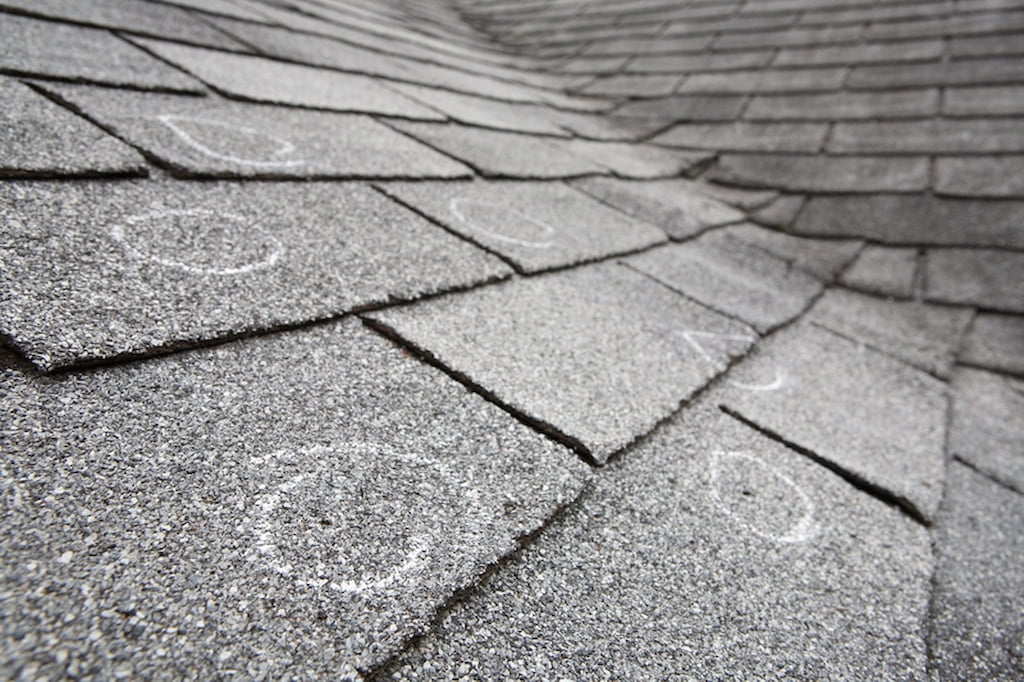 Roof damage identified with chalk on commercial rooftop during inspection