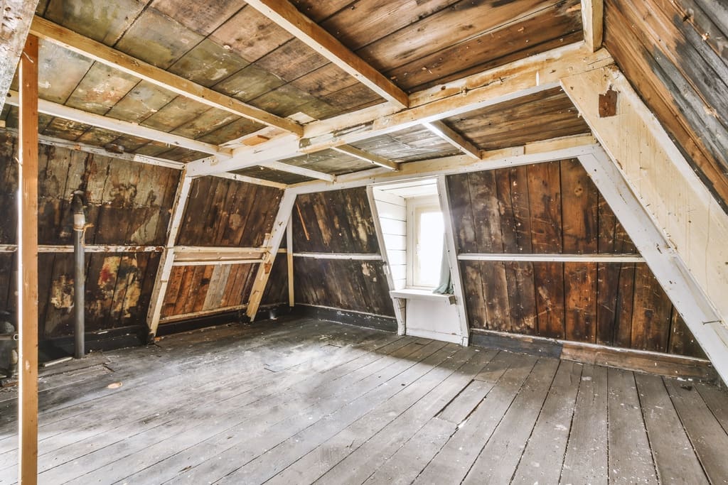 Attic with moisture damage visible on wall.