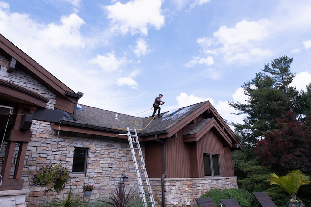 Roof Maxx professional applying treatment to help asphalt shingle roof last longer.