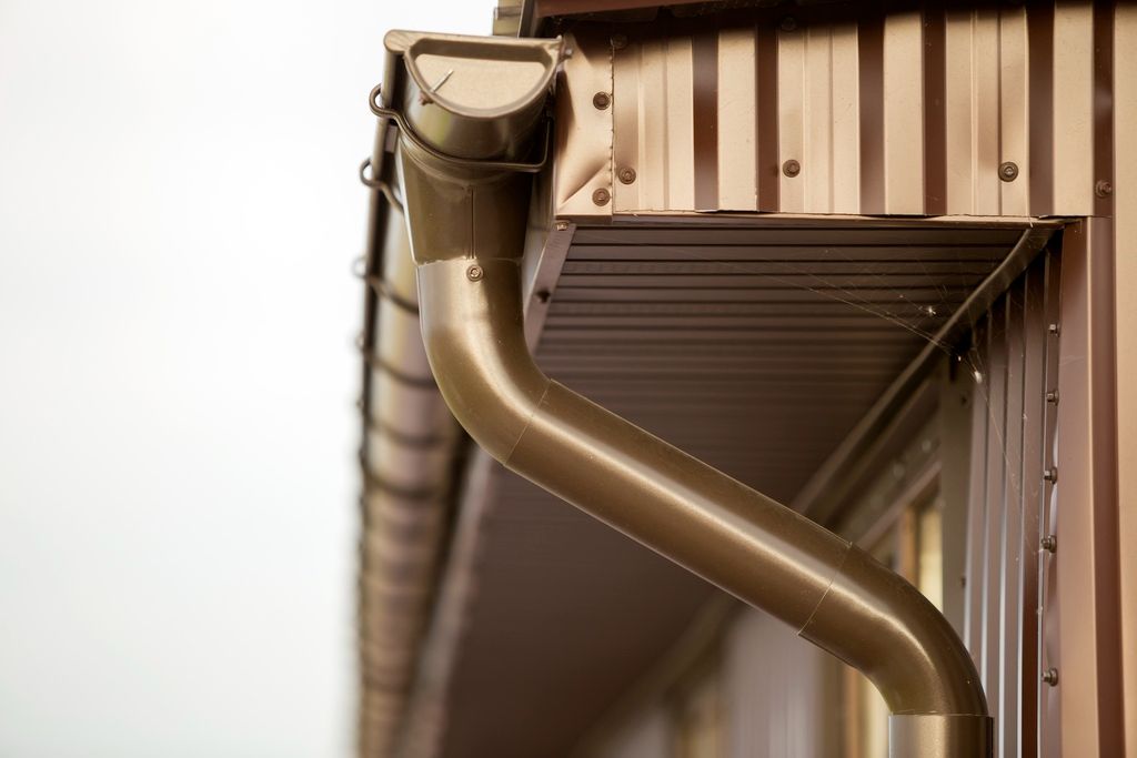 Close-up of round downspout on side of home