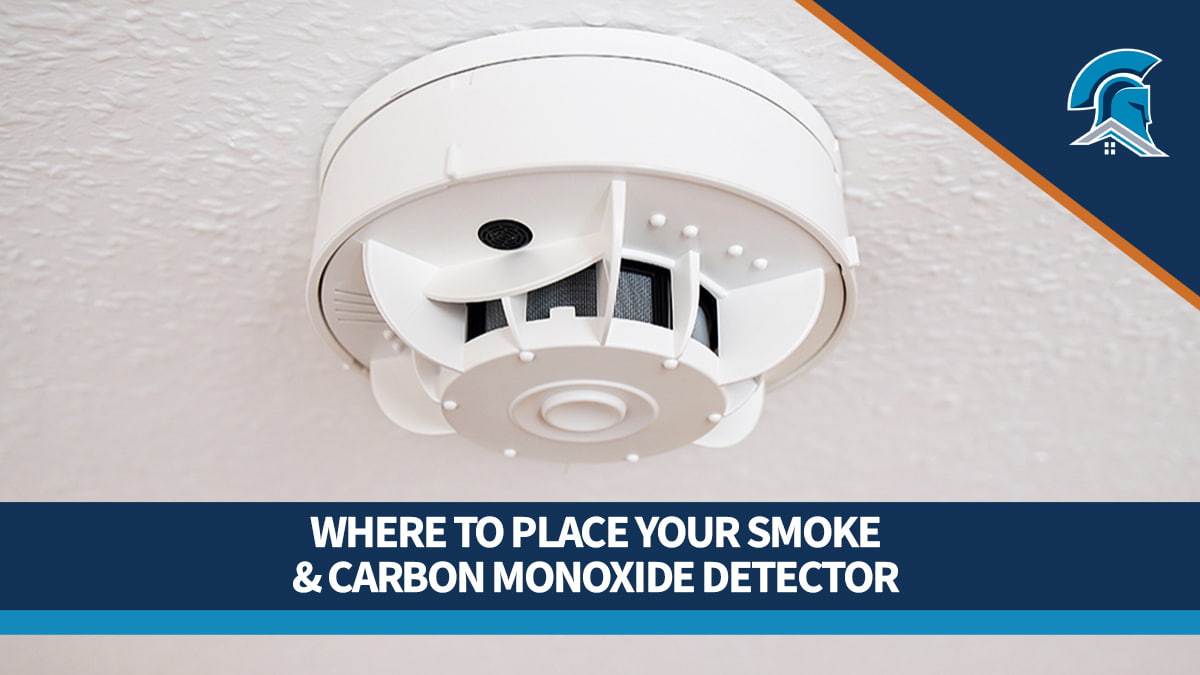 Close up of a white combination smoke and CO detector on a white speckled ceiling.