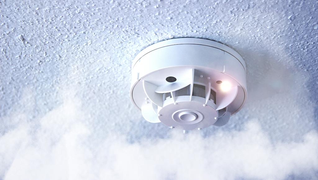 A beeping fire alarm warning someone about smoke.