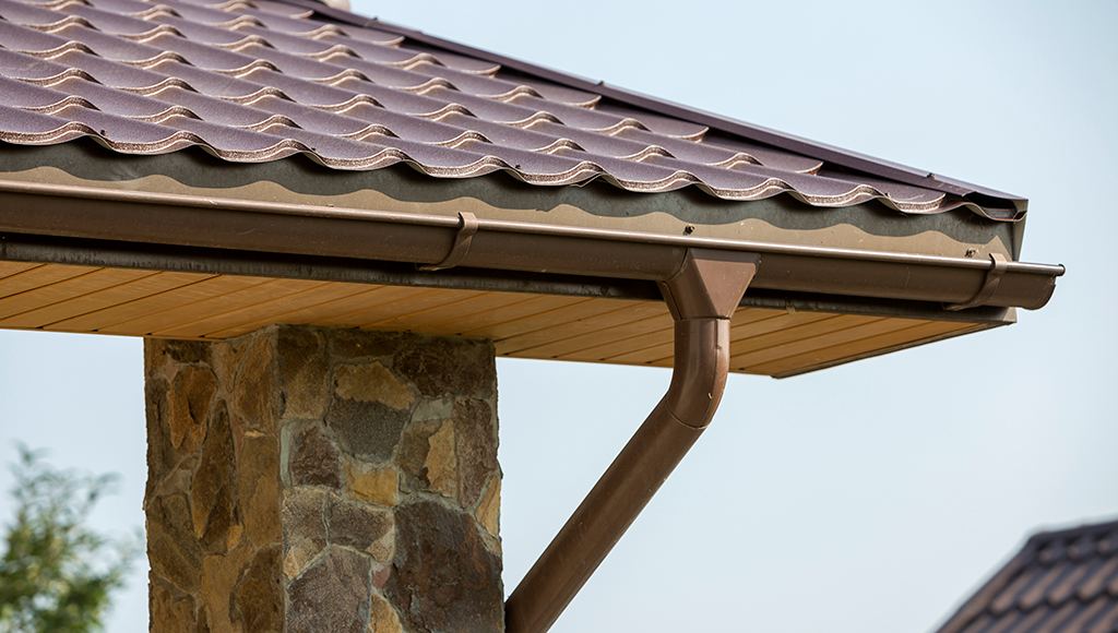 Copper gutter on a home with natural stone siding.