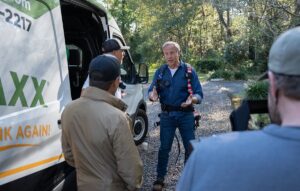 Mike Rowe speaks with Roof Maxx team members during a product demo outside a home in Florida