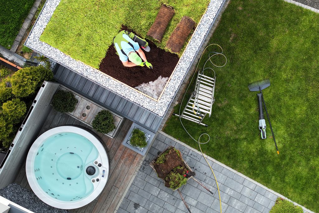 A homeowner works on laying down sod on a green roof
