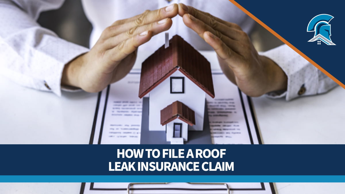 A person holds their hands over a tiny model home sitting on an insurance contract