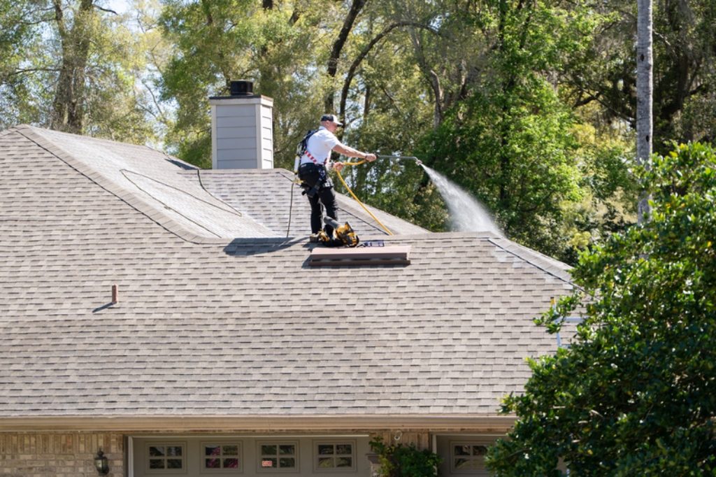 Roof Maxx professional spraying solution on asphalt shingle rooftop