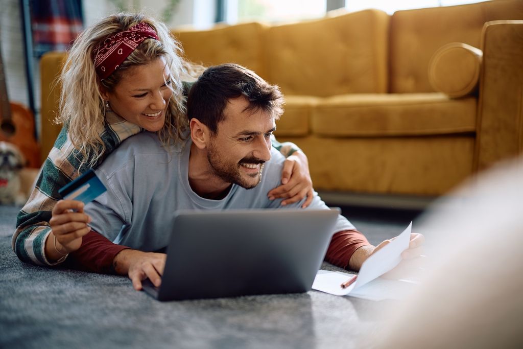 Young couple smiling while realizing they qualify for tax rebate on home improvement project