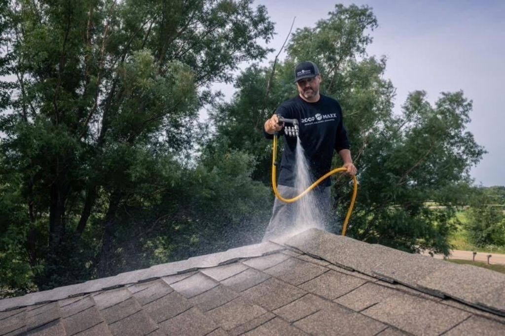 Roof Maxx dealer spraying asphalt shingle rooftop to help preserve lifespan