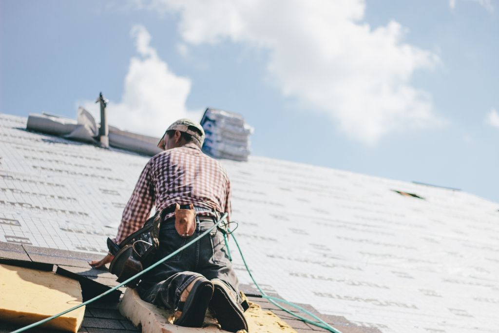 Roofing contractor starting to put shingles on top of roof underlayment for residential home