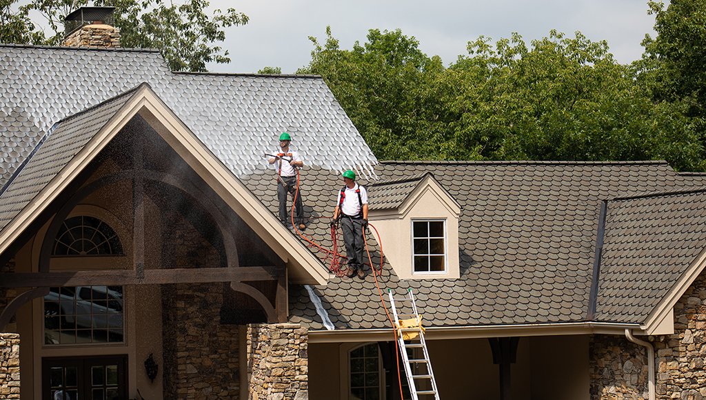 Two Roof Maxx technicians spray our soy-based solution onto a customer's roof.