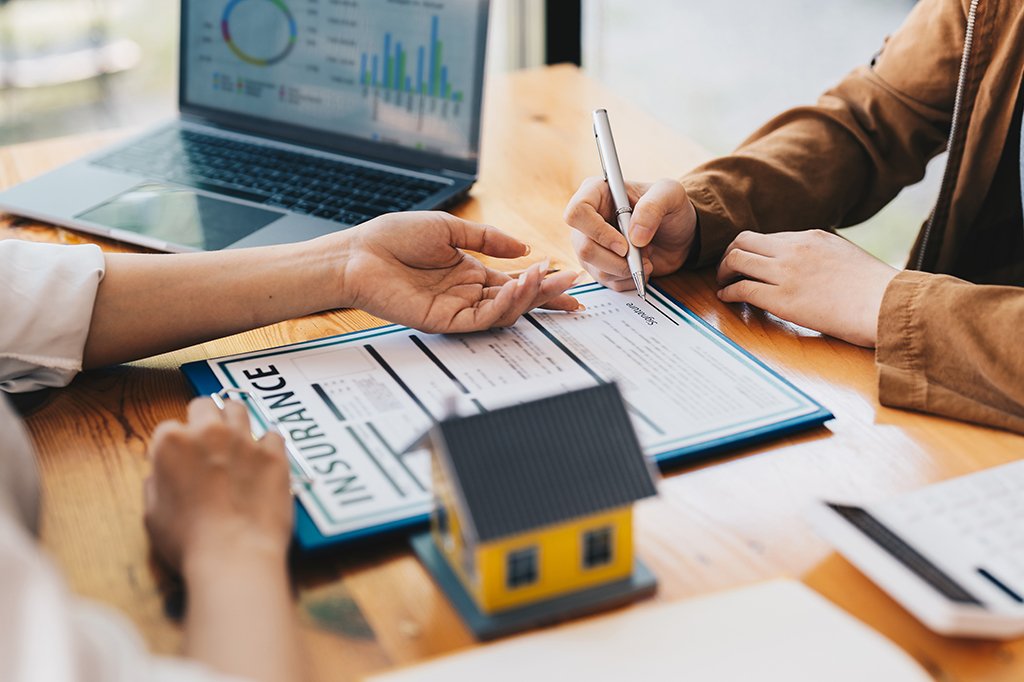 A homeowner signs an insurance policy after buying a home.