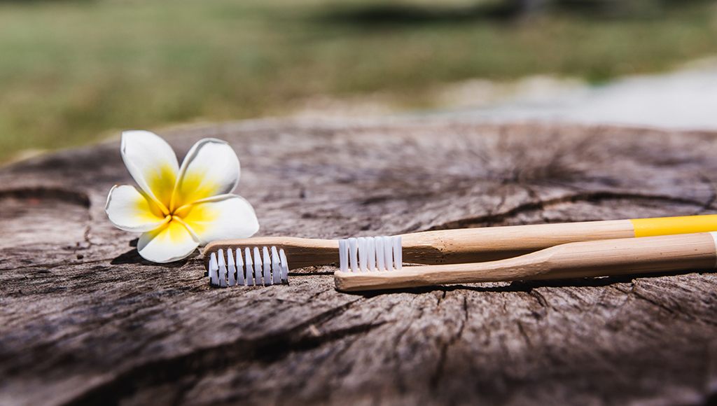A closeup of a bamboo toothbrush with nylon bristles.