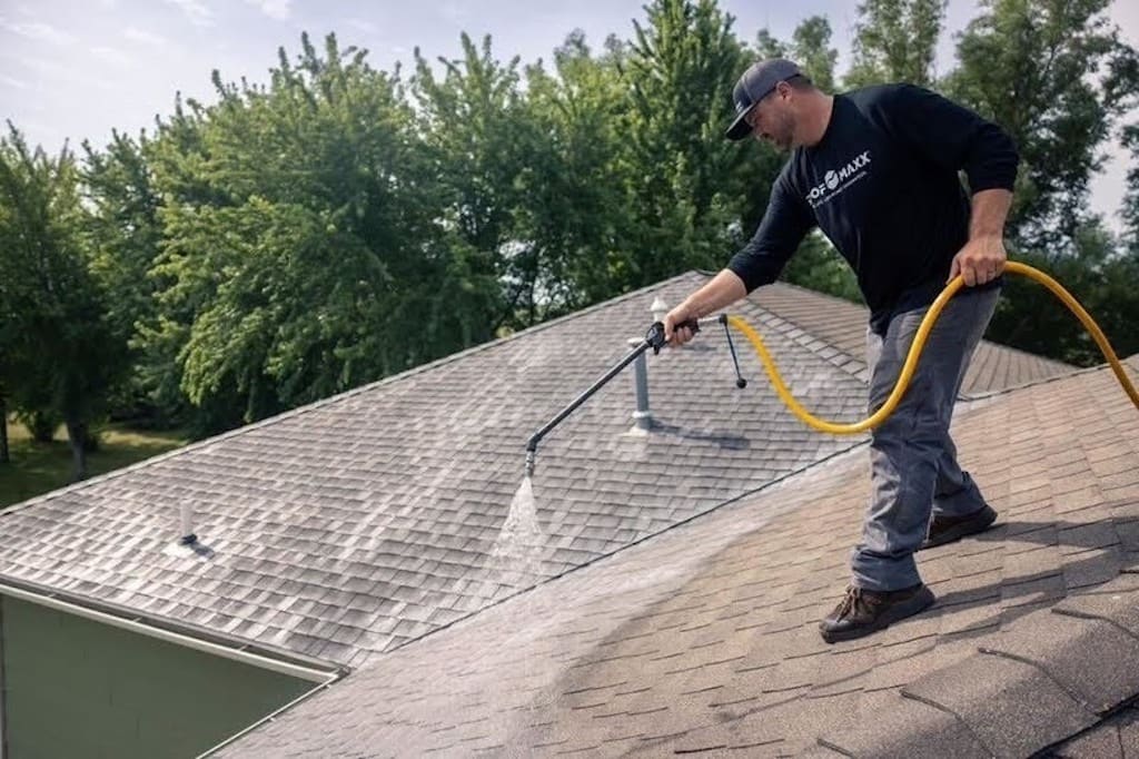 Roof Maxx professional applying solution to asphalt shingle rooftop