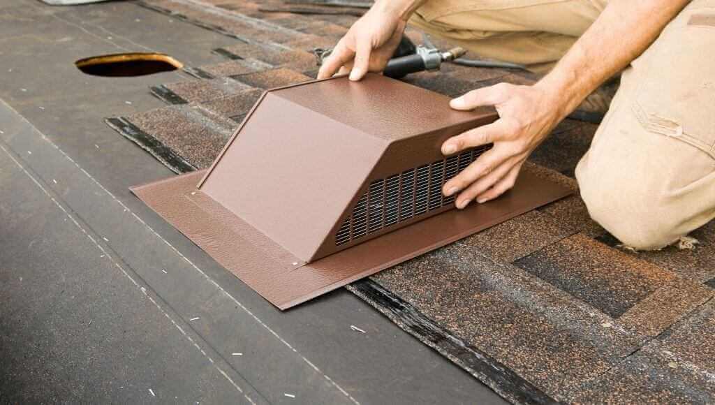 Man installing a box vent on an asphalt shingle roof.