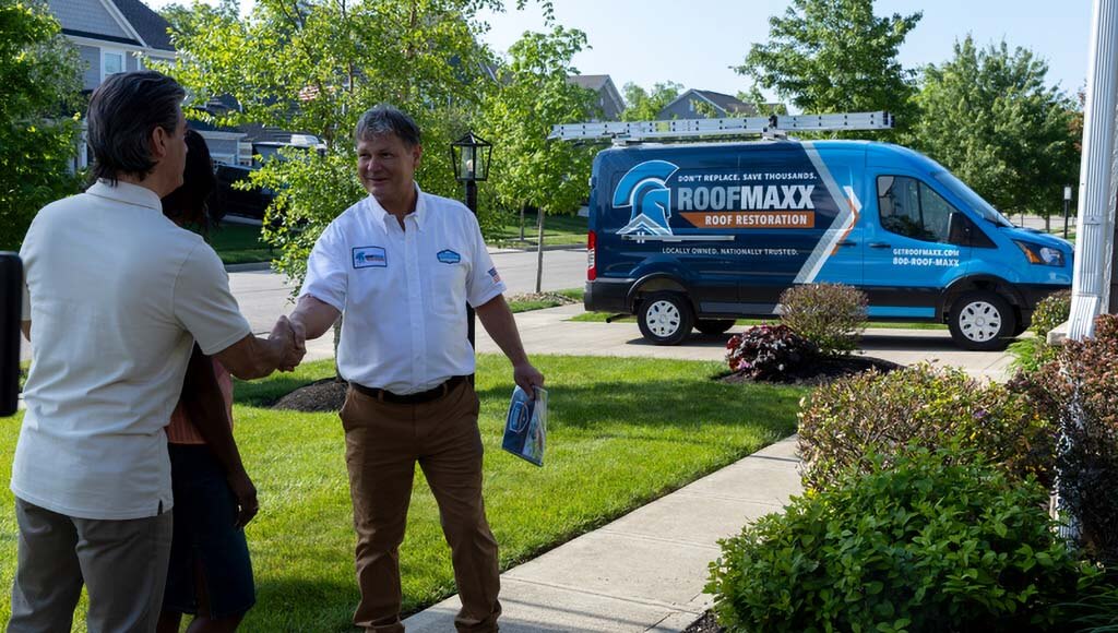 A Roof Maxx dealer shakes a customer's hand after completing a roof treatment service.