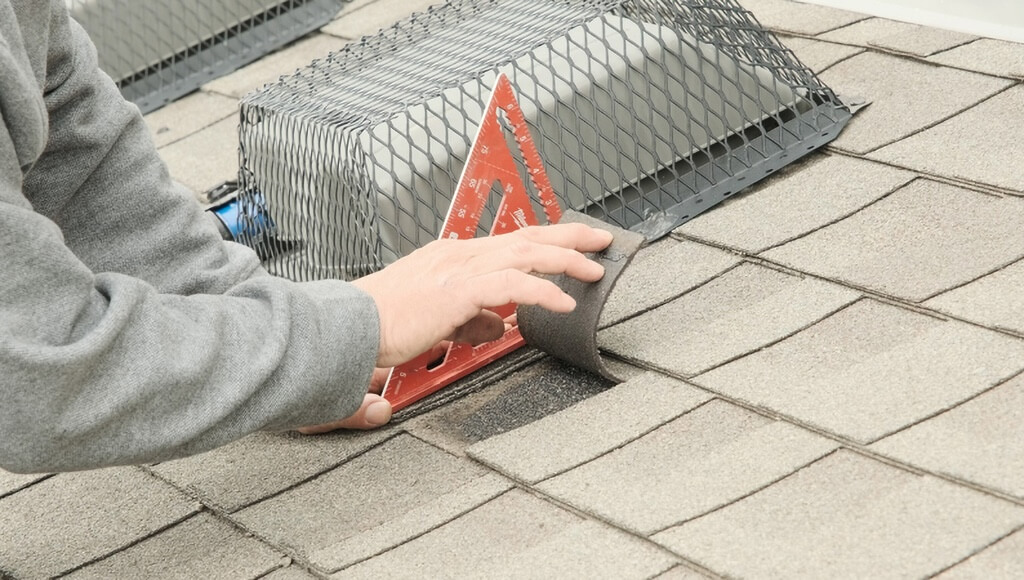 A roofer bends a new shingle to test the degree of flexibility still left in the core.