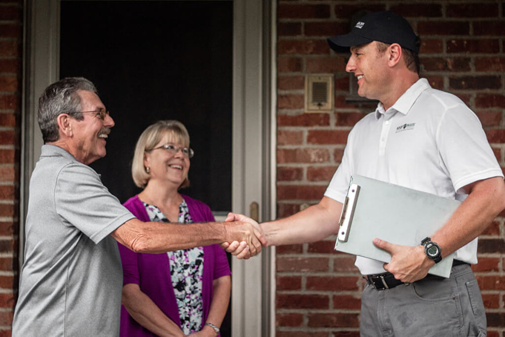 A Roof Maxx dealer introduces himself to two homeowners