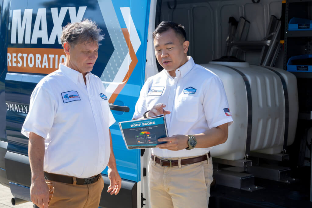 Two Roof Maxx dealers review a customer's roof score.