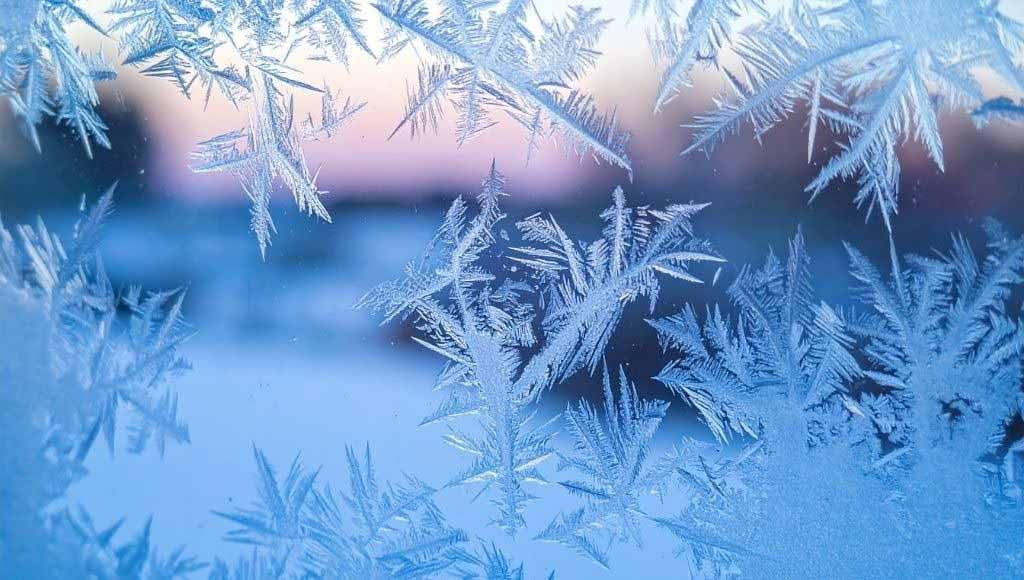A window partially covered by frost in the middle of the winter.
