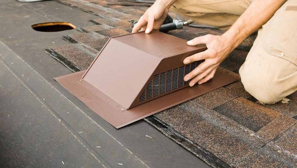 Man installing a box vent on an asphalt shingle roof.